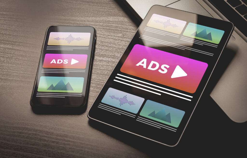 Mobile phone and tablet showing digital ads, symbolizing strategies to advertise your photography business online.