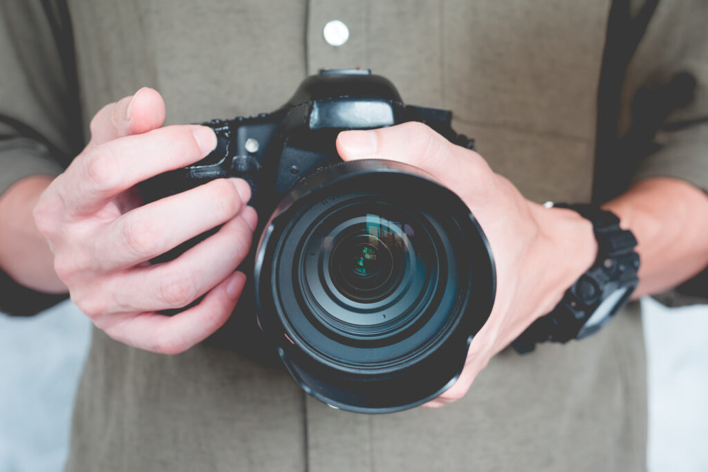 Close up of a Photographer Holding a Professional Camera Symbolizing the Guidance of a Business Coach for Photographers