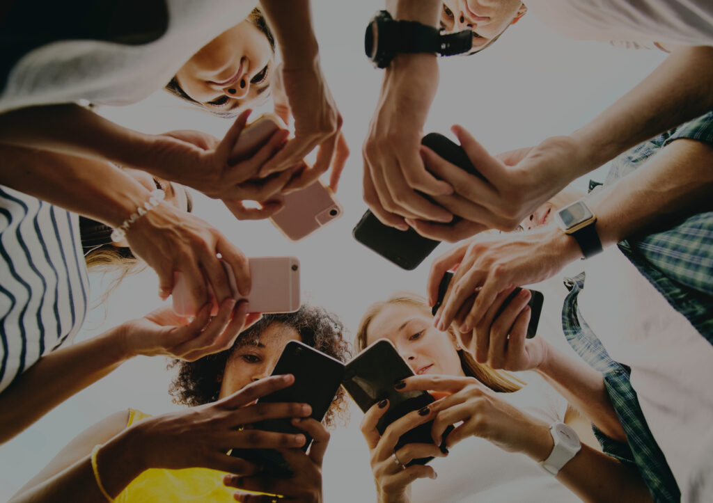 Group of people using smartphones together, symbolizing social strategies in mastering marketing for photographers.