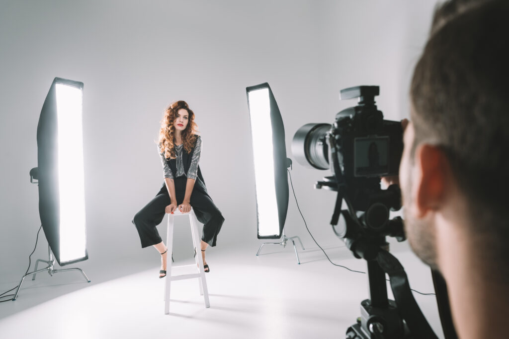 A professional photographer shooting a model with studio lights, offering inspiration for professional photographer blog ideas.