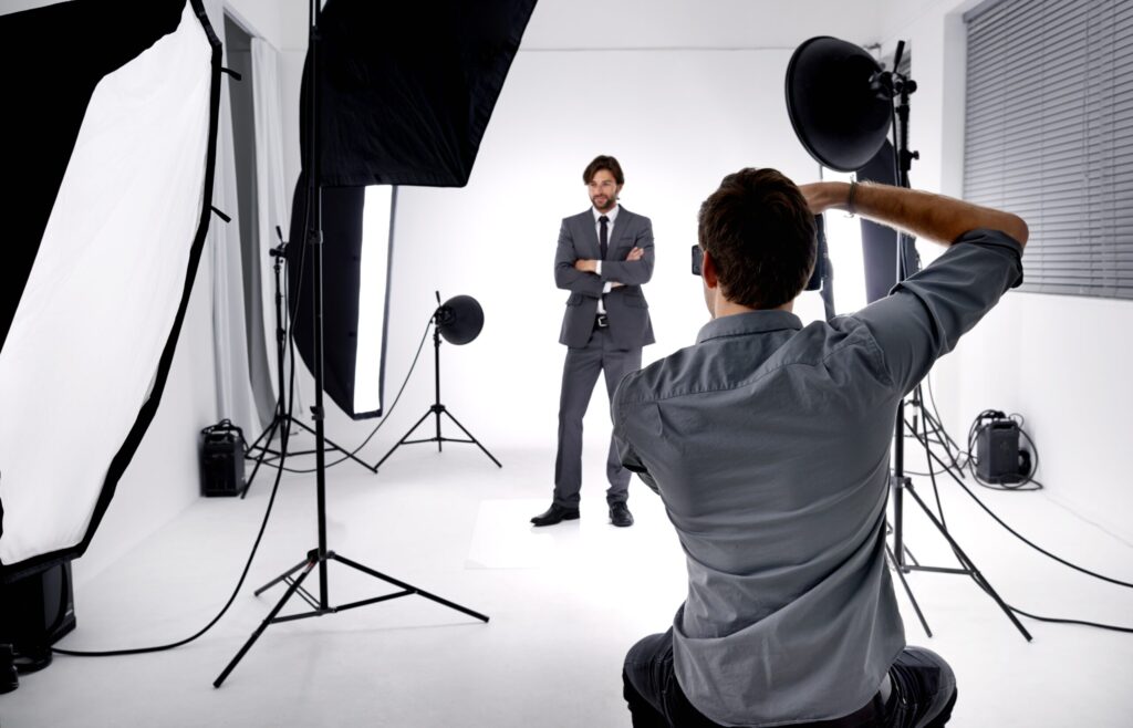 Photographer taking professional portraits in a studio setup, symbolizing strategies on how to get clients for real estate photography.