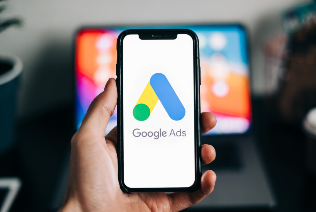 Close-up of a smartphone showing the Google Ads logo, symbolizing the question are Google Ads worth it for photographers looking to attract new clients.
