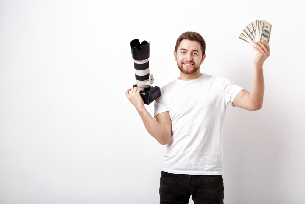 Smiling photographer holding a professional camera and cash, symbolizing profits from Photography Black Friday Deals.