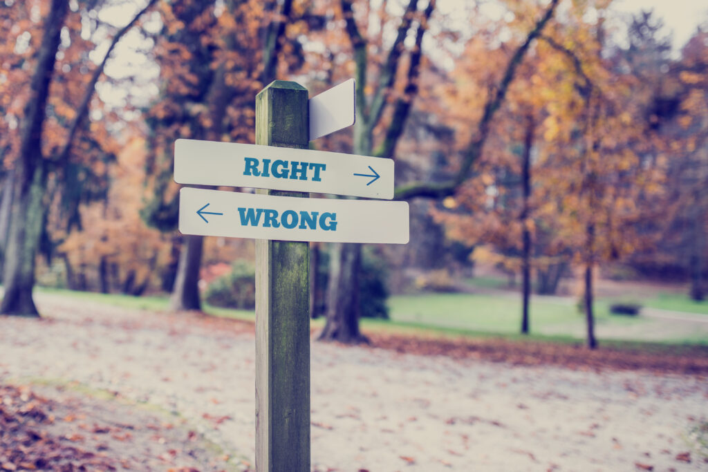 a Wooden Signpost in an Autumn Park Pointing to right and wrong Paths Symbolizing the Critical Decisions in Photography Business Coaching to Scale Beyond Shooting and Build a Thriving Studio