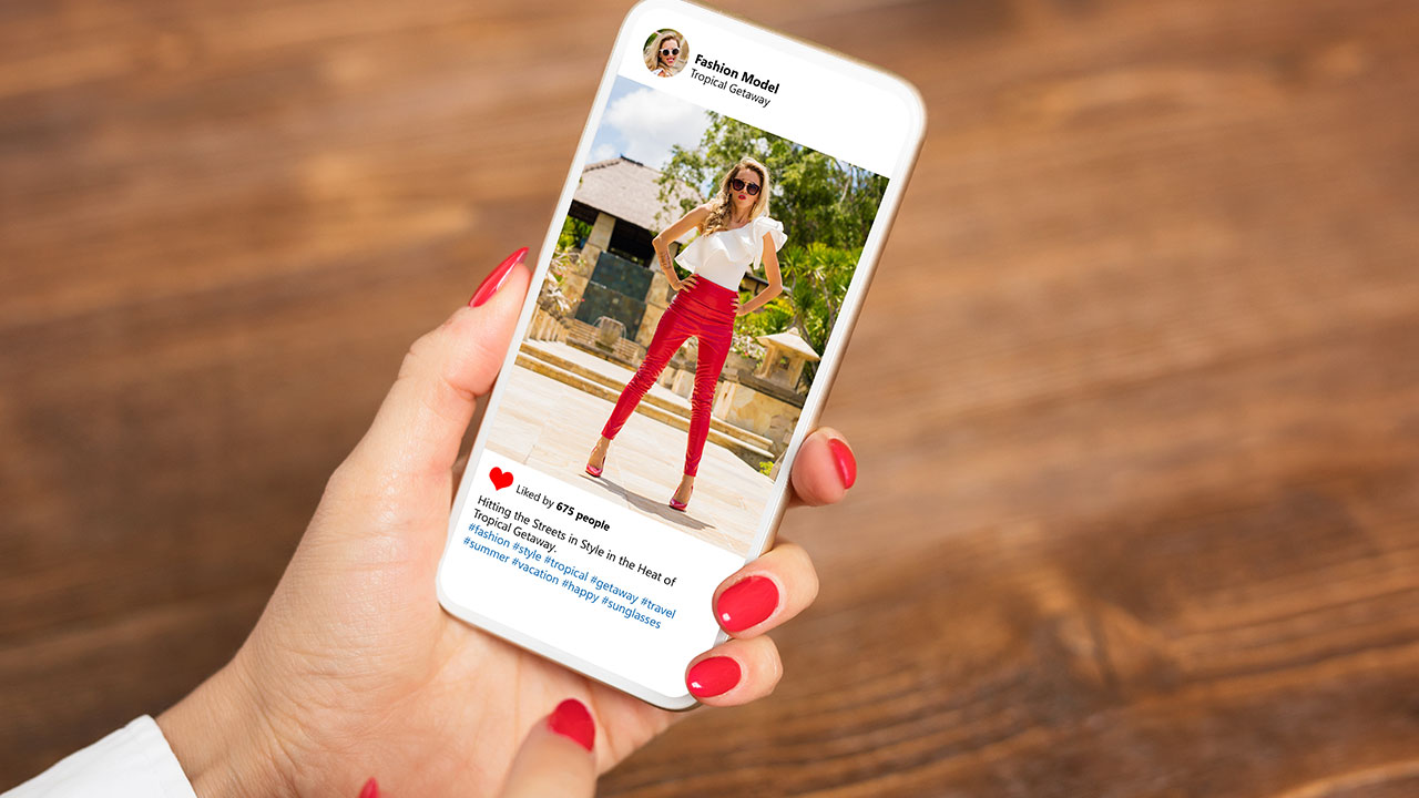 Hand holding a smartphone with an Instagram post of a fashion model, illustrating Instagram for photographers as a tool to attract and book clients.