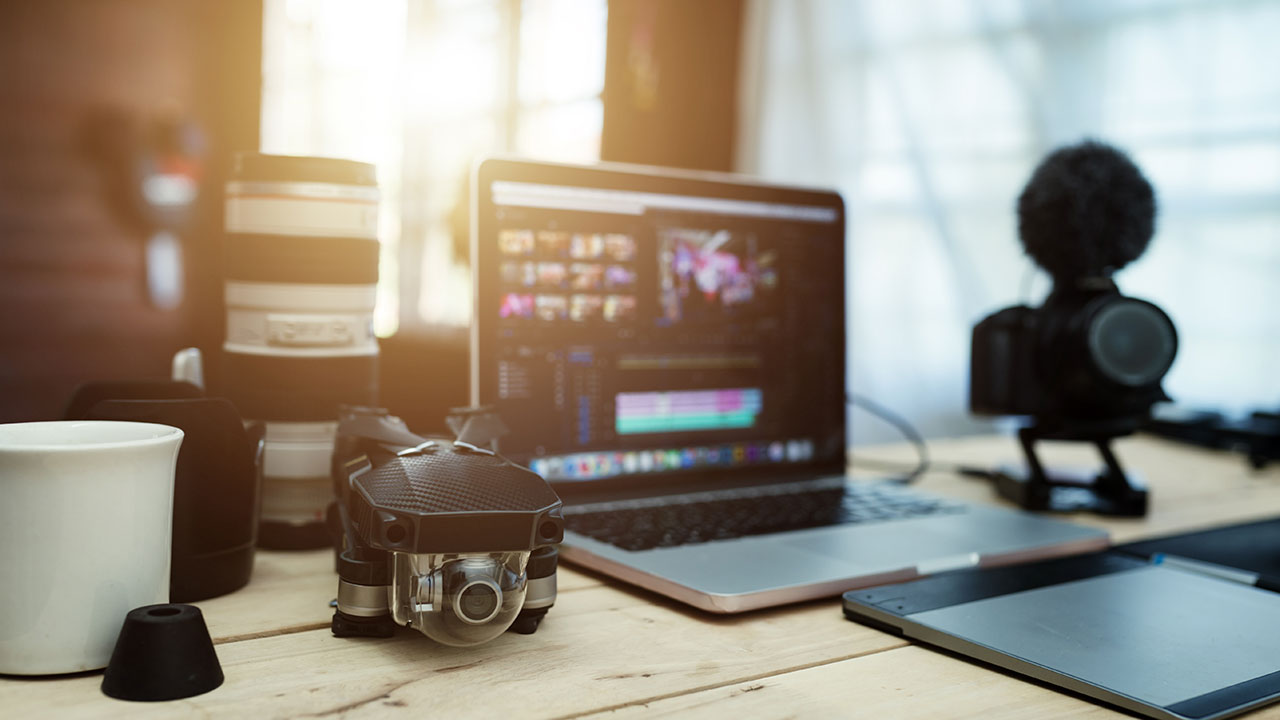 Photography equipment, laptop, and editing tools on a desk representing marketing vs PR for photographers and how each supports business growth.