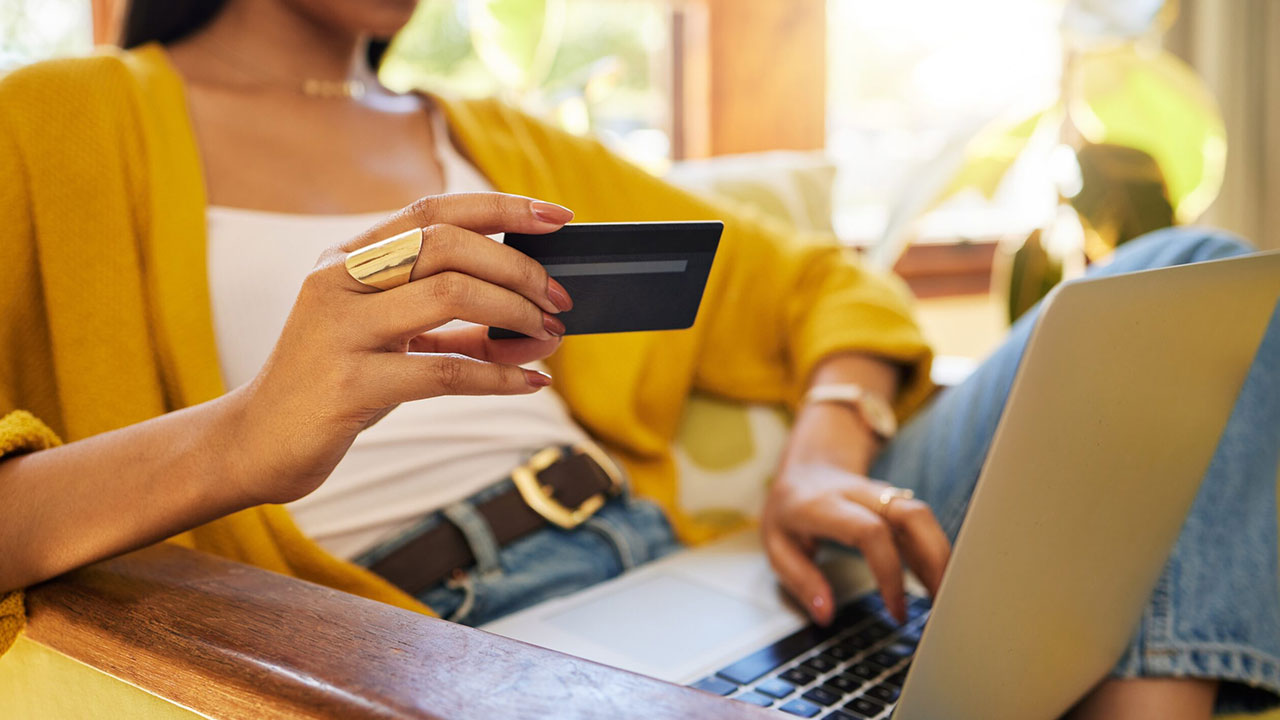 Close-up of a woman holding a credit card and shopping online, symbolizing photography Black Friday deals.
