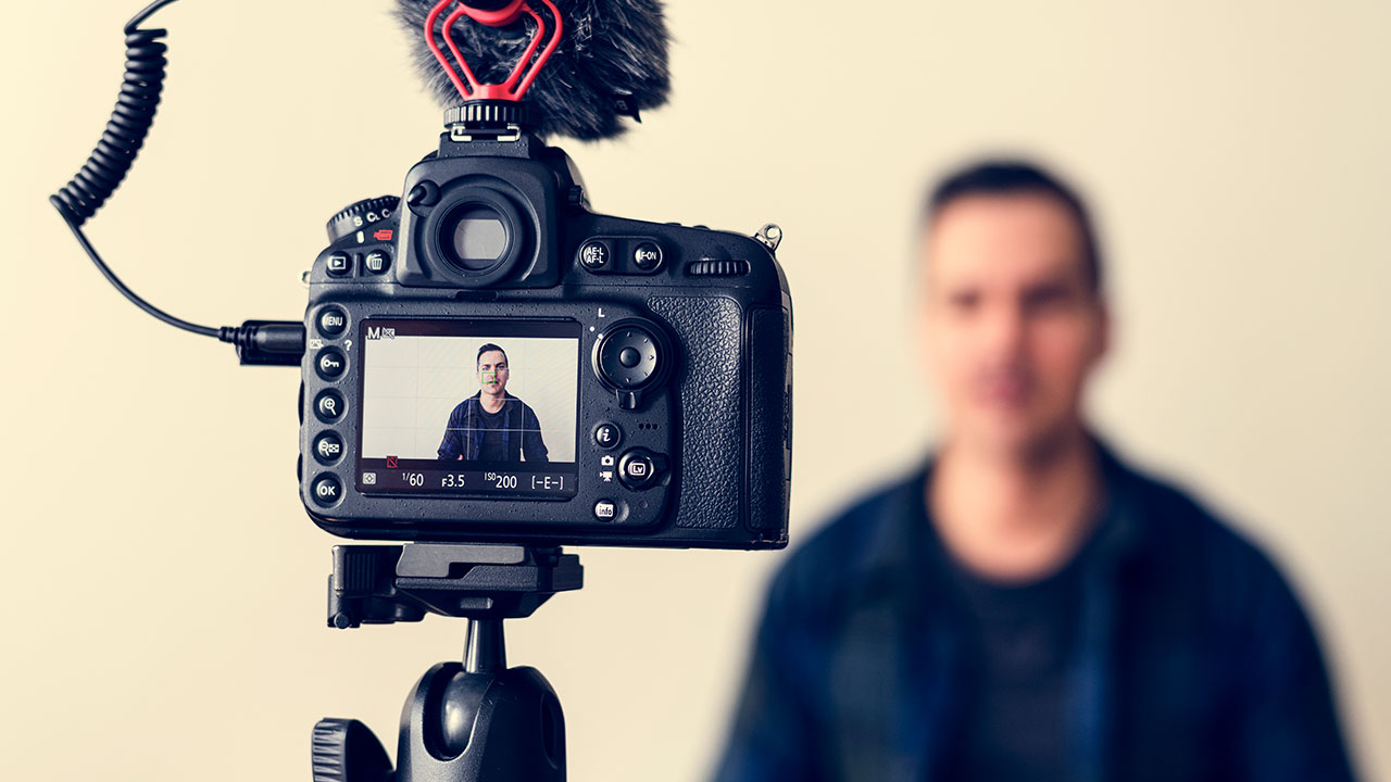 DSLR camera recording a photographer on video, representing content creation for social media for photographers.