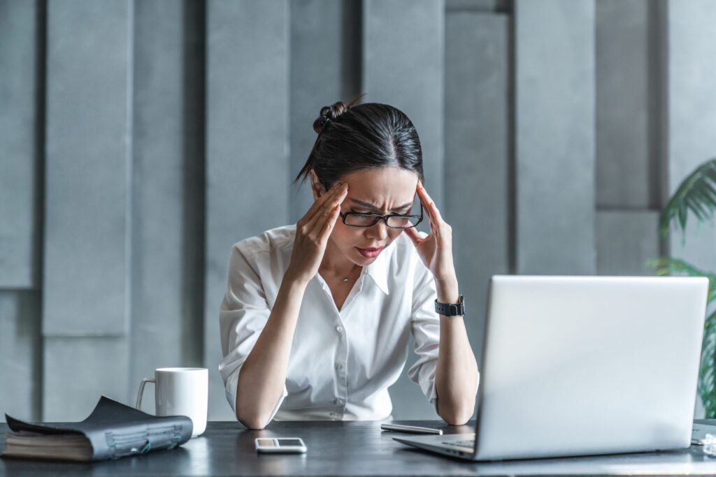 Stressed Photographer at a Desk with a Laptop Symbolizing the Challenges of Working Alone and Why Every Photographer Needs a Mentor