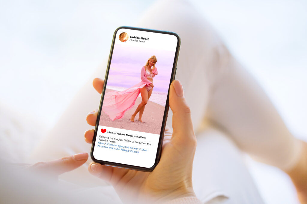 Person Holding a Phone Displaying an Instagram Post of a Model on the Beach Symbolizing How Social Media for Photographers Drives Visibility and Engagement