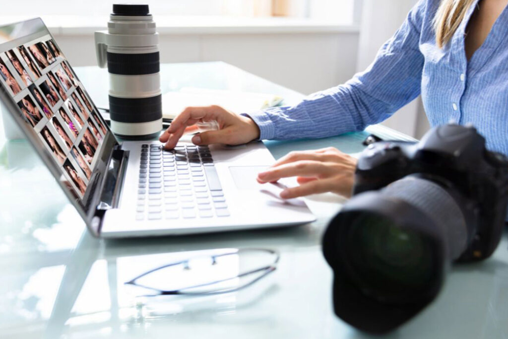 A happy couple reviewing photos on a tablet with a photographer, showcasing content strategies that connect when doing SEO for couples photographers.