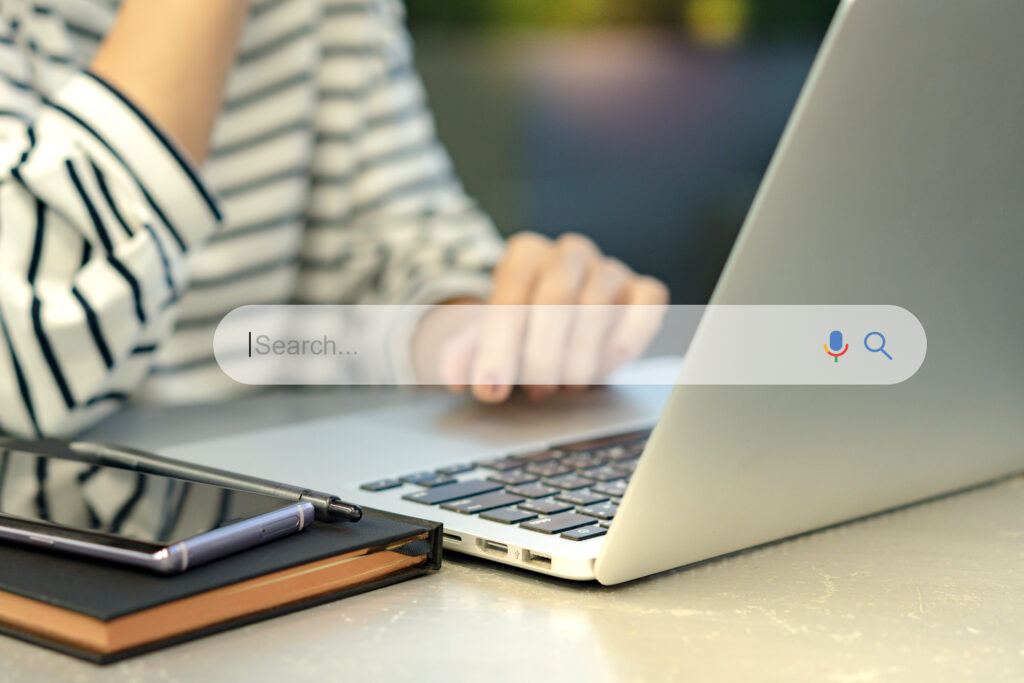 Person Using a Laptop to Search Online Representing Local Seo for Photography Websites and Improving Visibility in Search Results