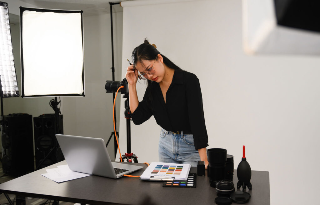 Photographer reviewing notes and marketing strategy in a studio, showing the role of marketing blogs for photographers in building consistent bookings.
