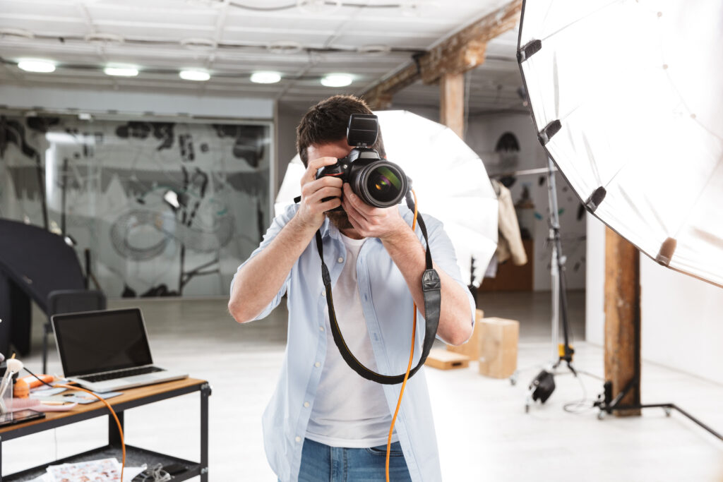 Photographer Working in a Studio with Camera and Lighting Setup Representing Pr and Paid Ads for Photographers