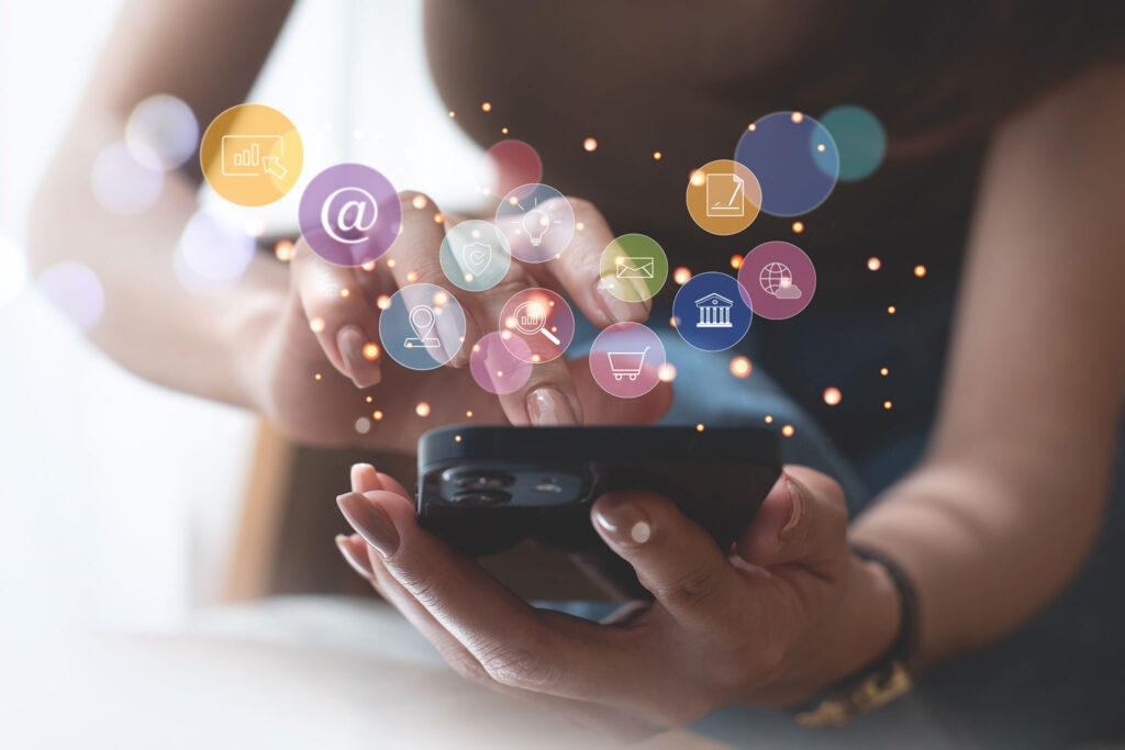 Close-up of a person using a smartphone with digital marketing icons, illustrating photography advertising examples on mobile platforms.