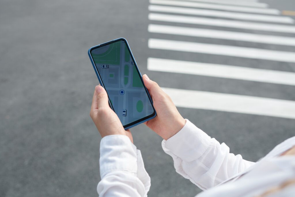 Hands Holding a Smartphone with a Digital Map Representing Local Seo for Photography Websites and Location based Visibility